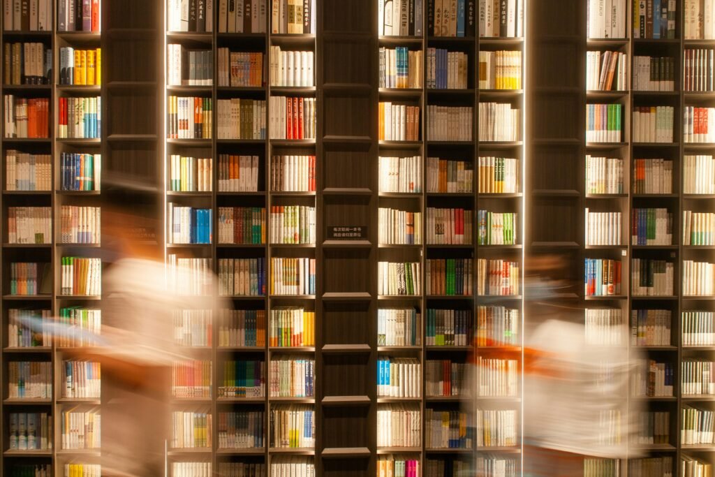 Research Papers Long exposure of people moving past bookshelves in a modern Shenzhen bookstore.